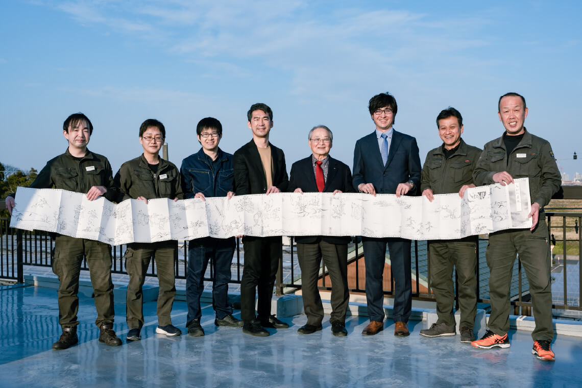 Group photo on the rooftop of the head office with the long-form printed materials using advanced technology.