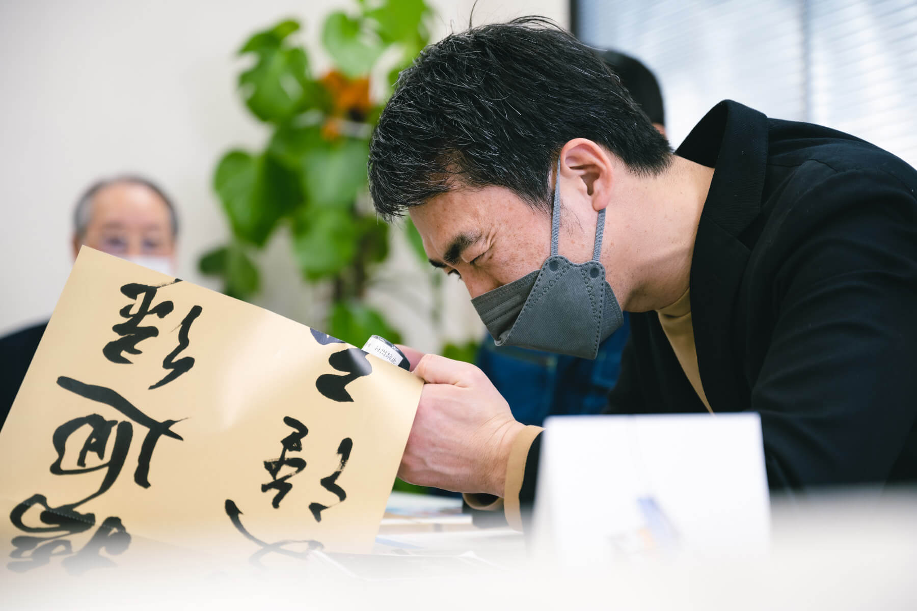 高精細な印刷物を凝視する天野さん